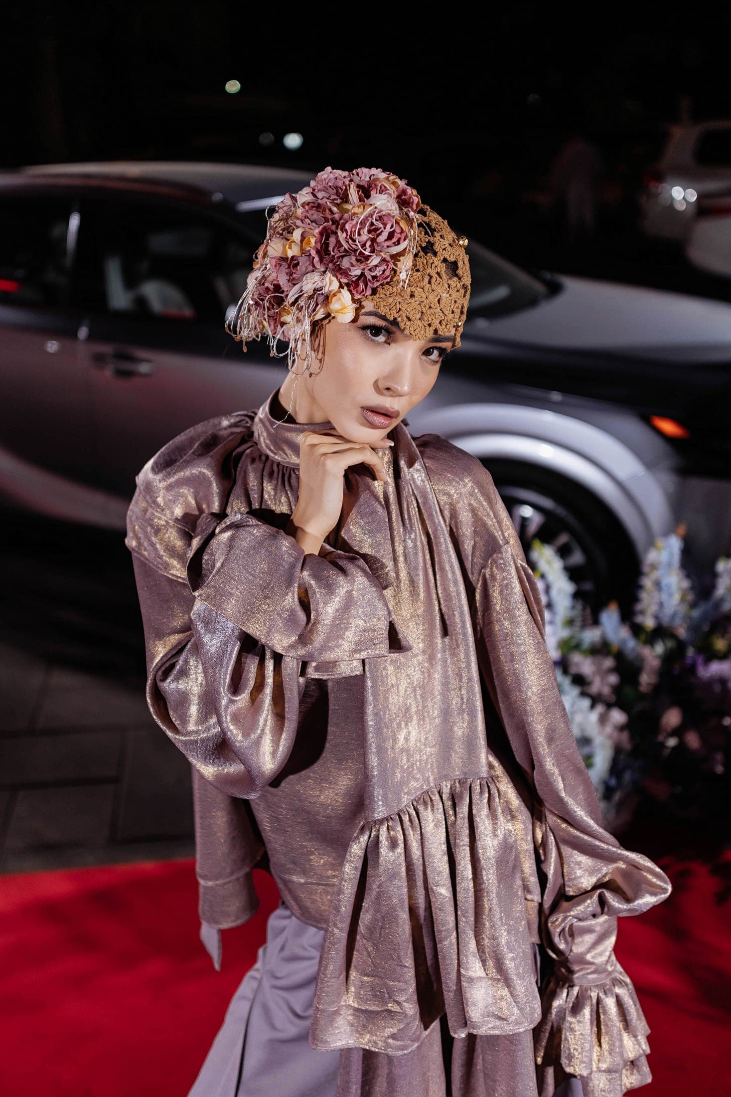 Close portrait of a model in a metallic rose-gold blouse with a dried-flower crochet headpiece