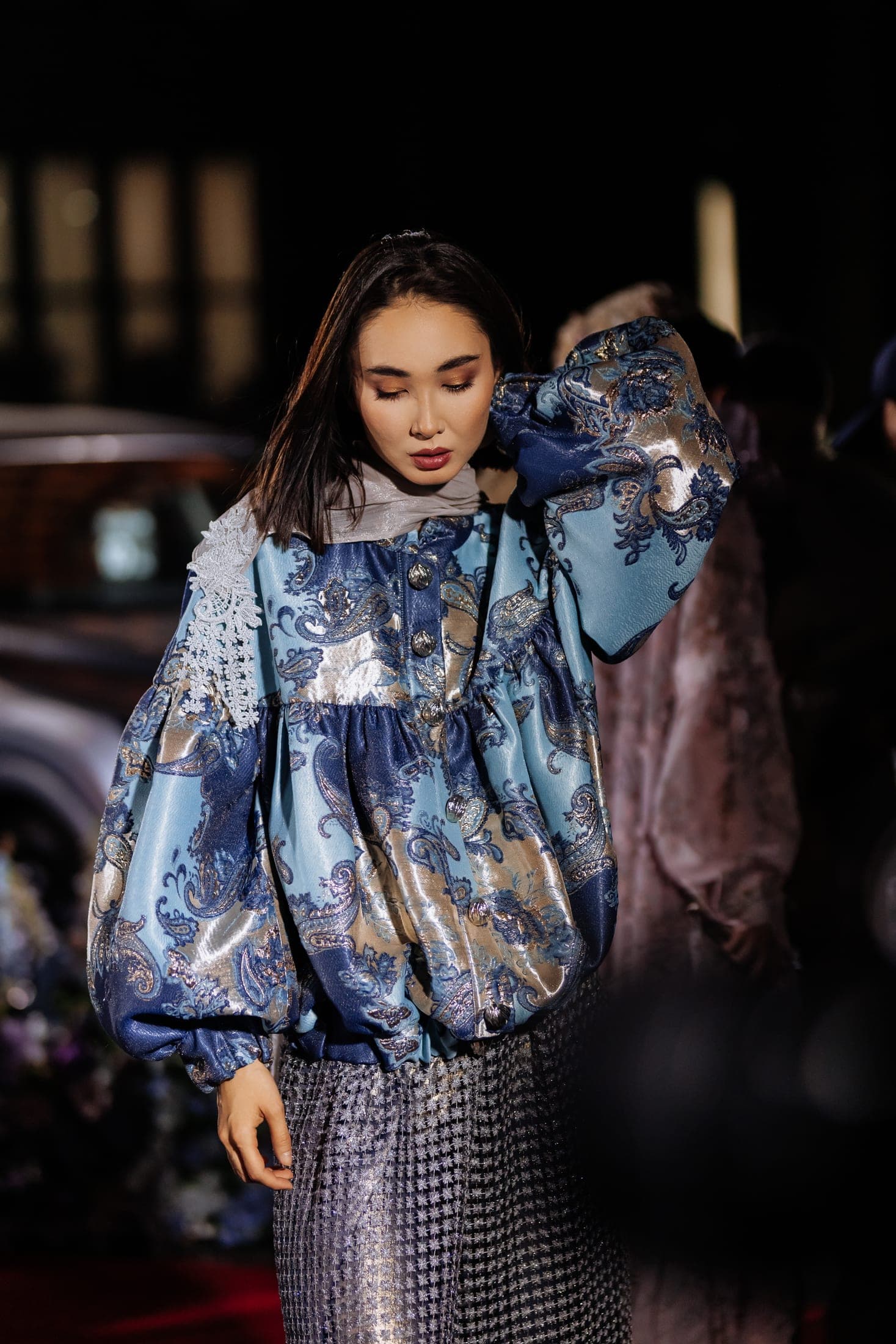 Runway finale — the designer and a model in turquoise walking out as the full cast applauds